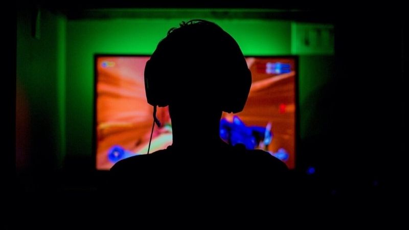 Silhuett av gamer med headset som kollar på streaming