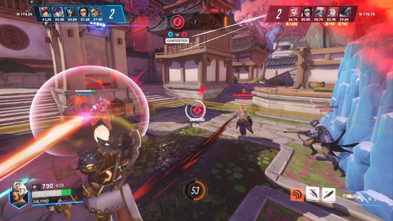 Spelare strider om kontrollpunkten i Overwatch 2, med flera hjältar och färgstarka effekter på skärmen.