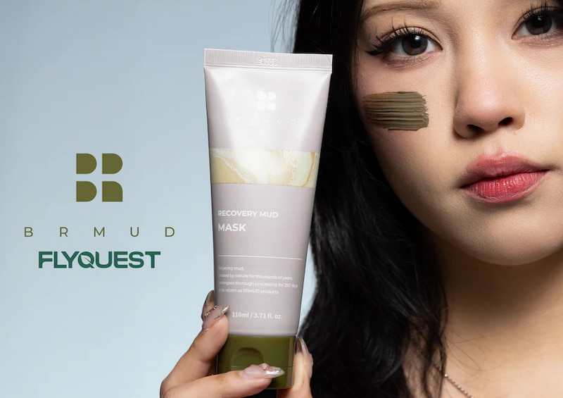 Person håller en tub BRMUD Recovery Mud Mask framför logotyperna för BRMUD och FLYQUEST.
