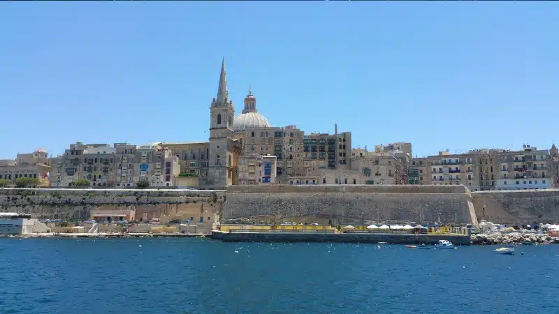 Vy över Valletta med St. Paul's Pro-Cathedral och stadens historiska byggnader vid vattnet.