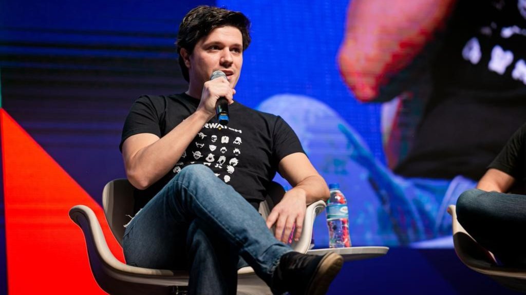 Screenshot of Marcos Pereira sitting with legs crossed on a chair