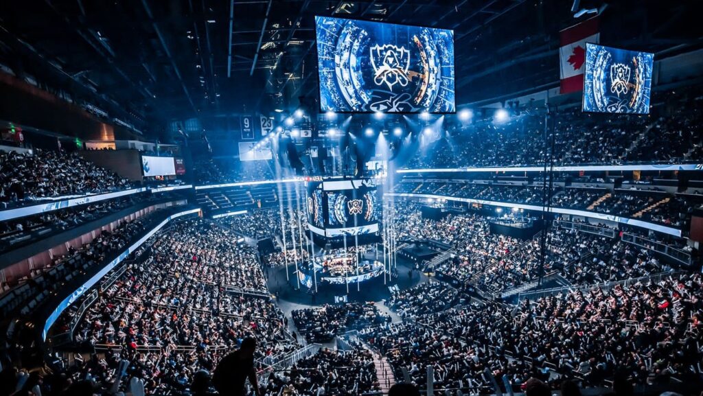 A packed arena filled with fans watching a live esports event, illuminated by dynamic lighting and large screens displaying the competition.
