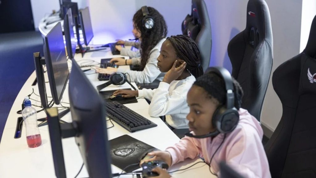 Image of children playing games sat at a desk