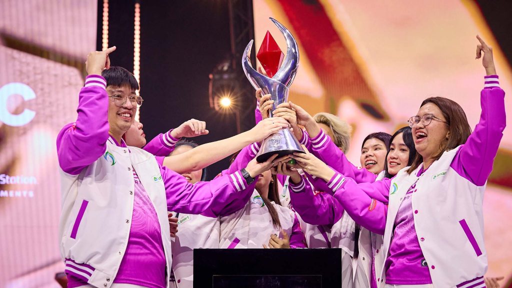 Mobile Legends team celebrating with trophy on the stage of an esports tournament