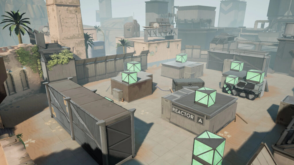 Aerial view of an industrial game map featuring crates, palm trees, and glowing energy cubes in a desert-like environment.