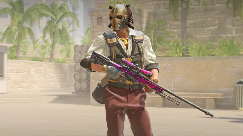 CS2 character in a golden mask holding a pink and black AWP sniper rifle, standing on a sunlit map with palm trees.