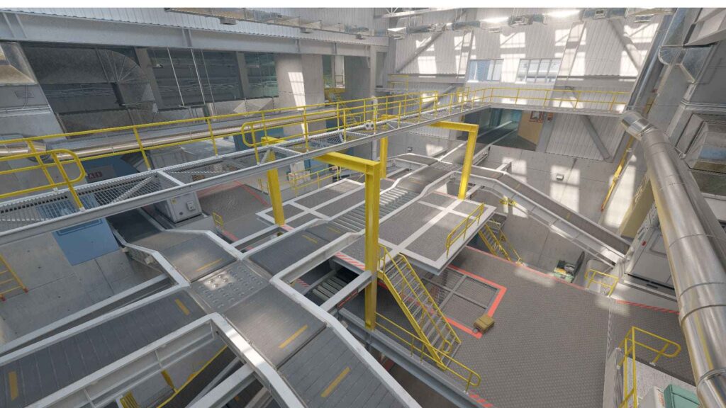 A modern industrial space featuring multiple walkways, yellow safety railings, and metal stairs, illuminated by natural light.