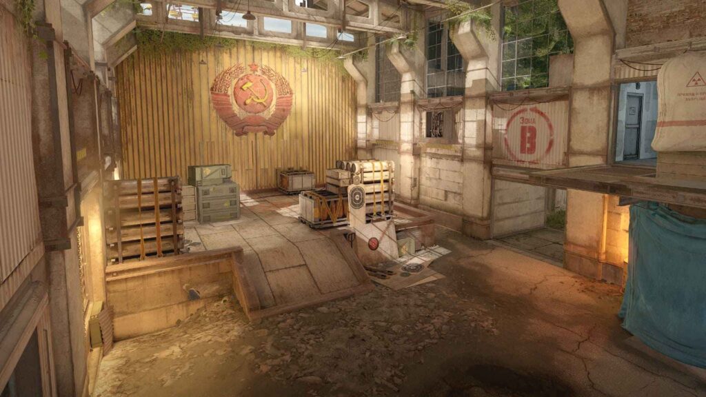 An abandoned industrial space featuring Soviet emblem, wooden crates, and target practice setup, illuminated by soft light and foliage.