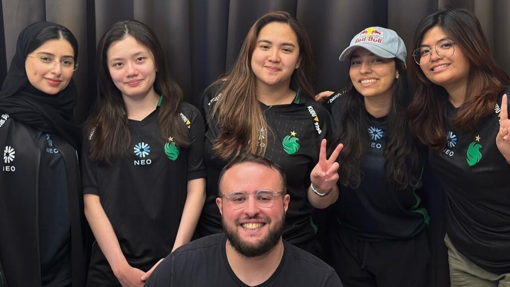 Falcons Vega team wearing black shirts with a green logo, posing together with cheerful expressions against a dark background.