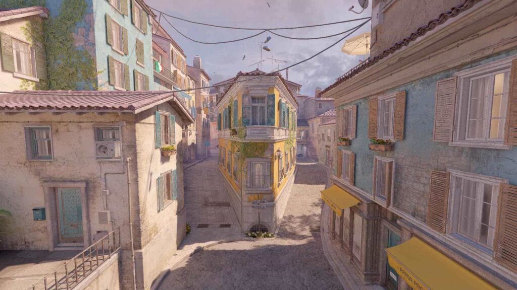 A picturesque European street scene featuring colorful buildings, cobblestone paths, and charming balconies adorned with plants.