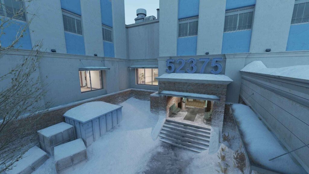 Snow-covered exterior of a building with the number 52375 displayed above the entrance, featuring frozen stairs and a window with a plant inside.