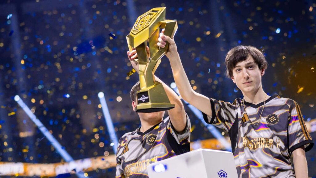 Peterbot celebrates a Fortnite championship win on stage with a teammate holding a golden trophy amid confetti and lights.