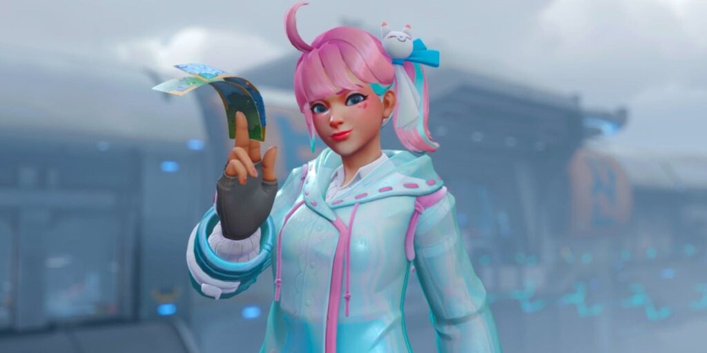 A stylish character from Overwatch in a light blue outfit with pink accents holds a colorful card, set against a futuristic background.