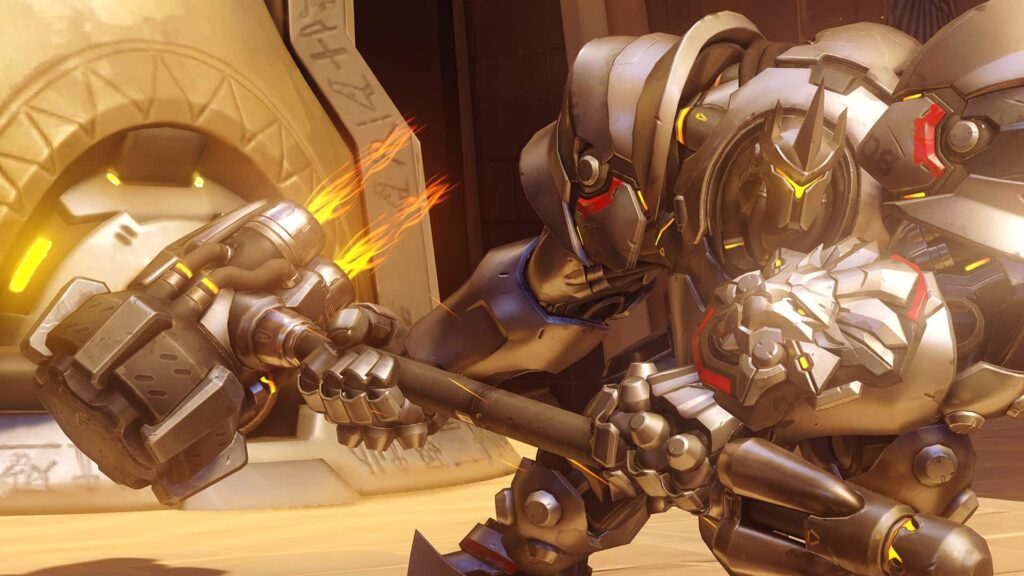 Reinhardt from Overwatch in full armor swinging his rocket hammer with flames, in a temple-like environment.