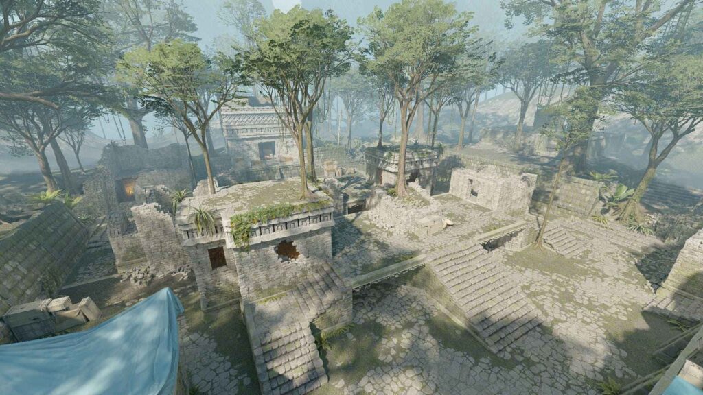 An aerial view of ancient, overgrown ruins surrounded by lush trees and mist, showcasing stone structures and winding pathways.
