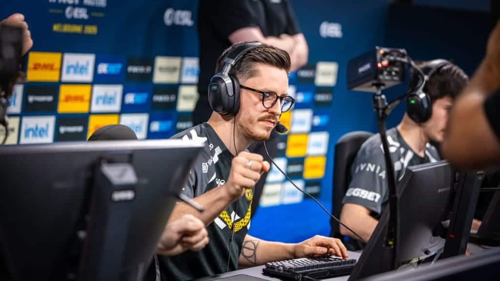 Team Vitality's apEX celebrates during a live CS2 match at IEM Melbourne, wearing a headset and gaming jersey in front of his monitor.