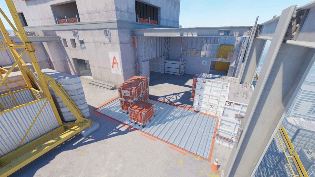 An industrial construction site with stacked metal containers, a yellow crane, and concrete walls under a clear blue sky.