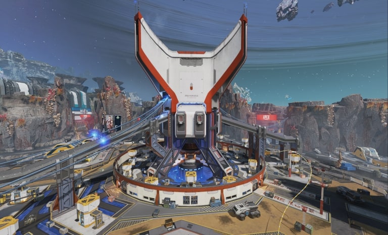 A futuristic circular structure with multiple zipline rails extending from its center, set in the rocky sci-fi landscape of the Apex Legends map Broken Moon, with space debris and a large planetary ring visible in the sky.