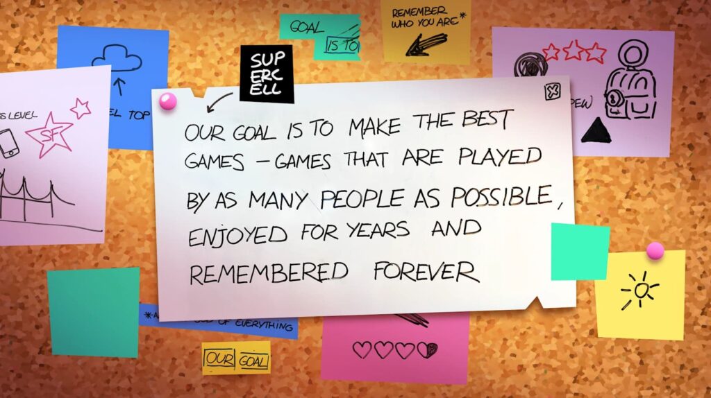 Notes on a corkboard featuring Supercell's goal: to create memorable games enjoyed by many for years. Colorful sticky notes surround it.