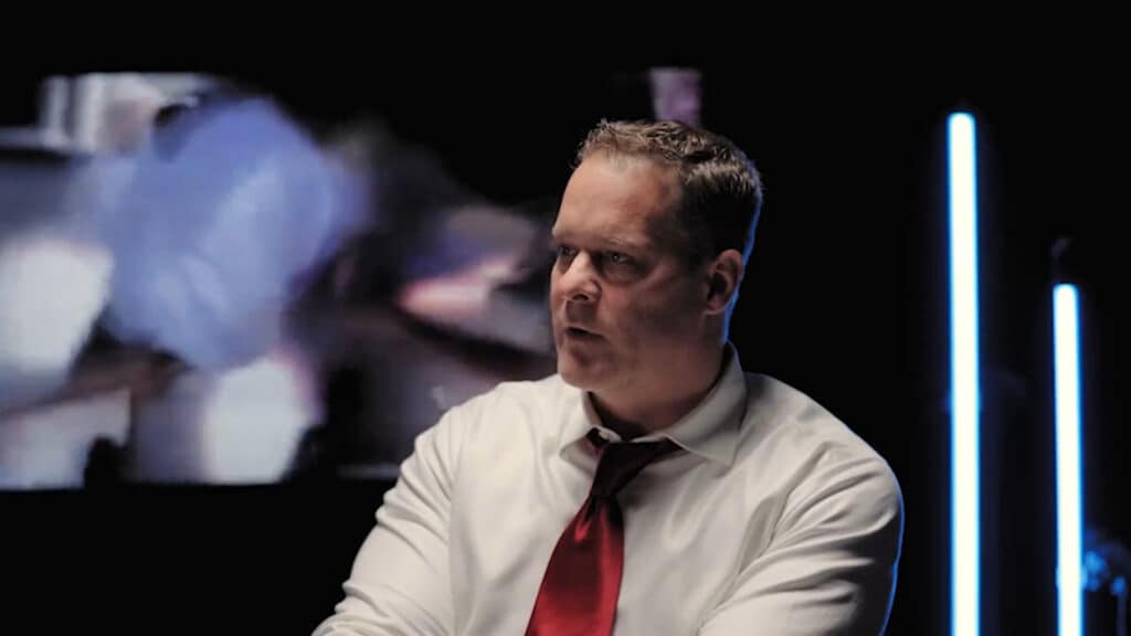 Image of Complexity CEO Jason Lake wearing a white shirt and a red tie