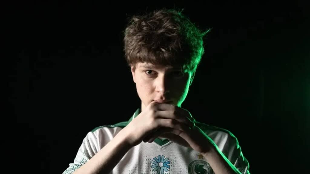 Image of Kyousuke posing with hands in front of face while wearing a Team Falcons jersey