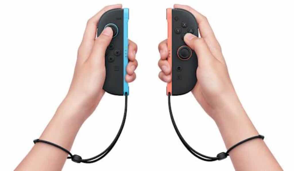 Hands holding blue and red Nintendo Switch 2 Joy-Con controllers with wrist straps
