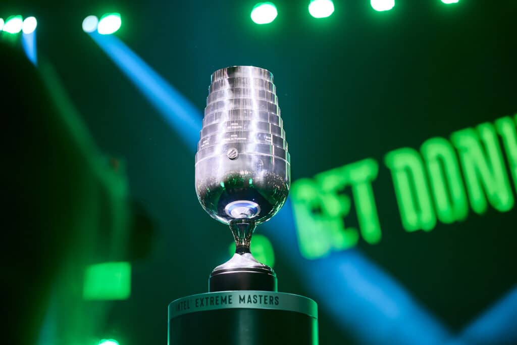 Image of IEM Cologne trophy on small stand. Green and white lighting are illuminating the trophy