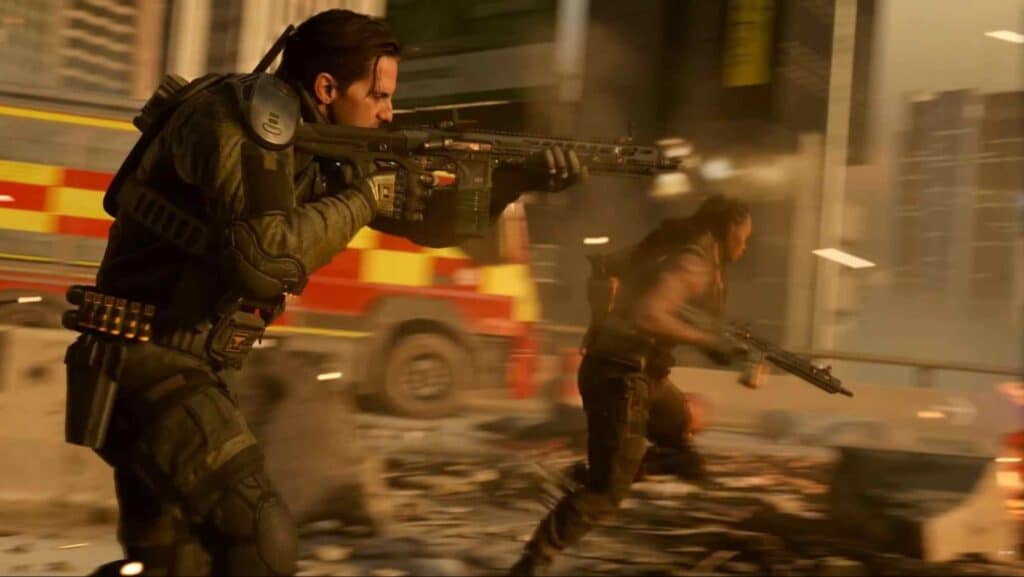 Two armed soldiers sprint through a chaotic scene of debris and smoke, with an emergency vehicle in the background.