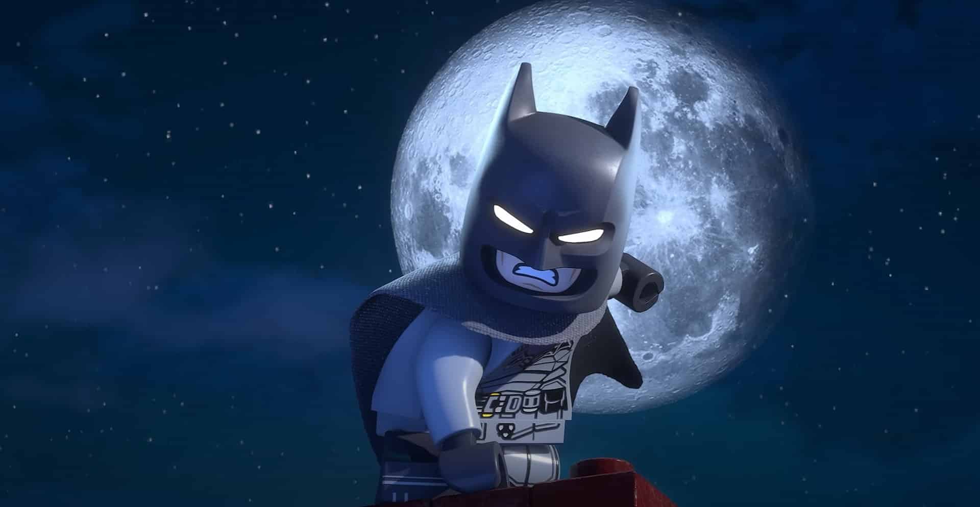 Lego Batman stands defiantly on a rooftop, silhouetted against a full moon in a starry night sky