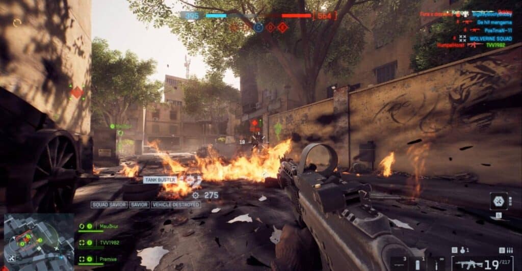 First-person view in Battlefield 6 with rifle aimed during urban combat and flames on the street.