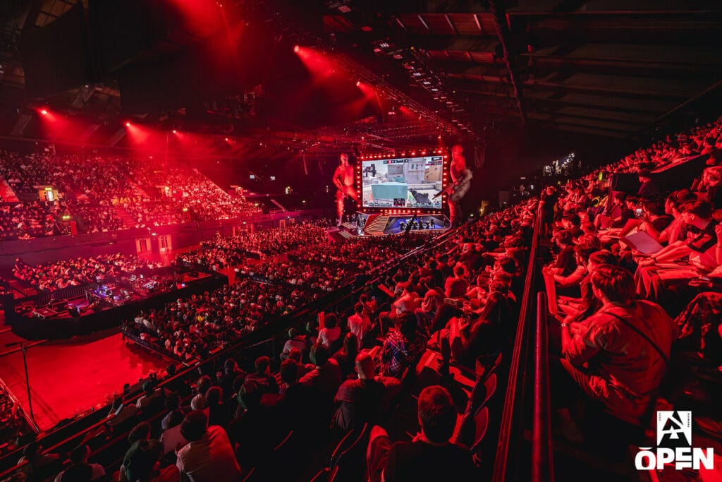 Image of BLAST Open London crowd watching Counter-Strike match taking place on stage in the background. A screen displaying gameplay hangs above the stage