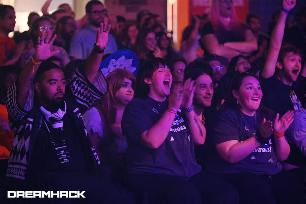 A large crowd cheering at a DreamHack esports event, illuminated by stage lights.