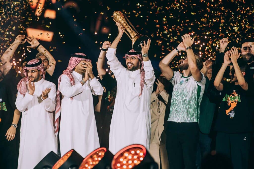 Image of Team Falcons representatives lifting Esports World Cup trophy