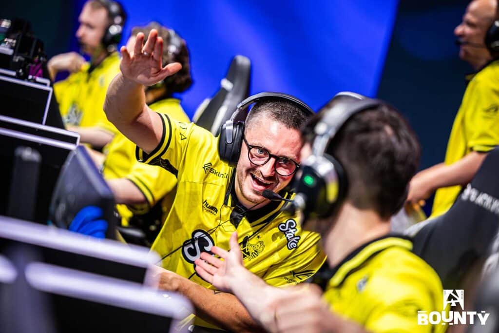 Image of Counter-Strike player apEX offering high-five to teammate sat next to him