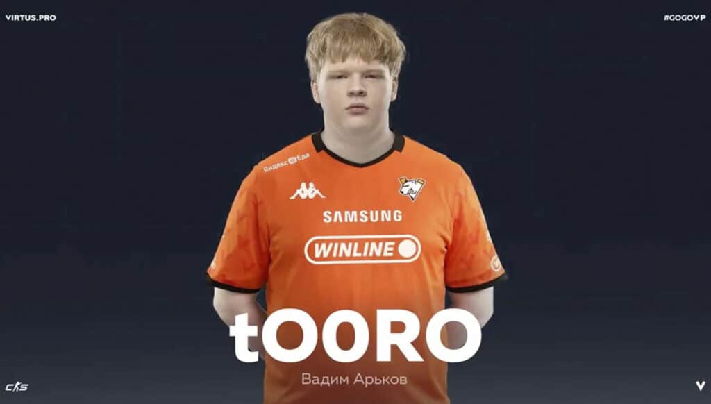 Image of Counter-Strike 2 player tO0RO with hands behind back while wearing Virtus.pro jersey on a dark blue background