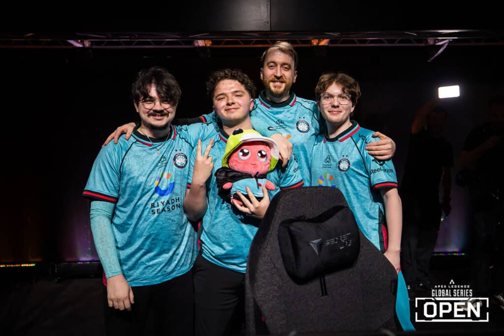Image of Twisted Minds Apex Legends team posing in front of gaming chair while holding a teddy wearing a Twisted Minds jersey