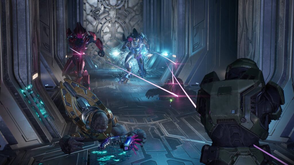 Un soldato futuristico in armatura affronta creature aliene in un corridoio metallico in Halo