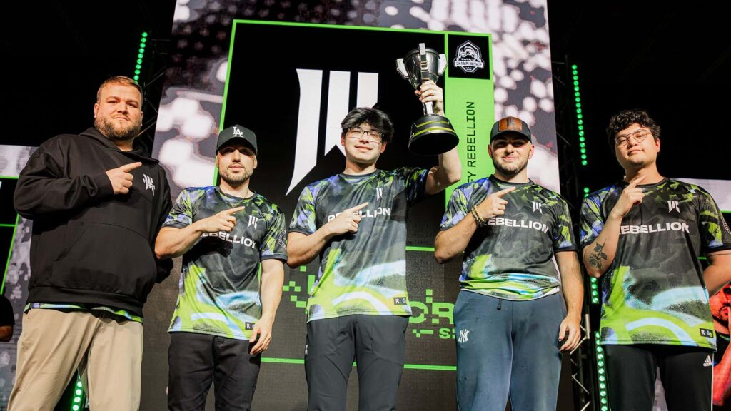 Uma equipe de cinco pessoas vestindo camisas combinando estava orgulhosamente no palco.