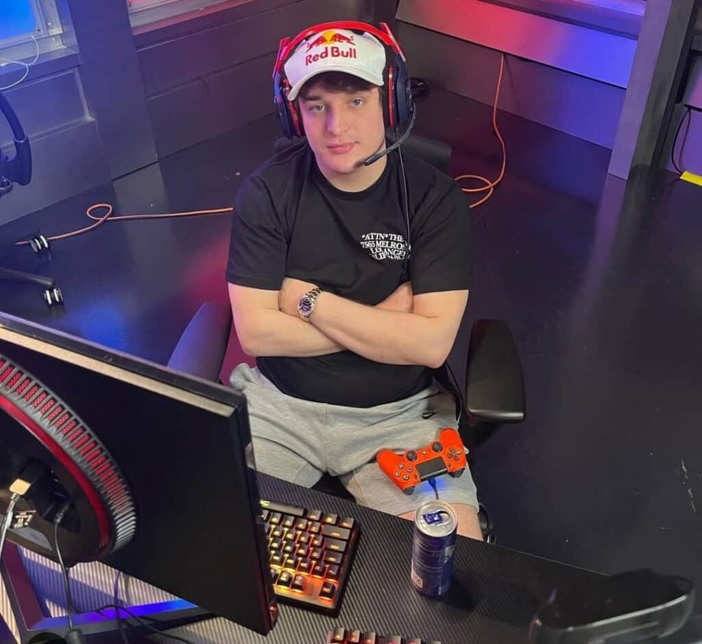 Jukeyz sits at his gaming setup wearing a Red Bull cap and headset