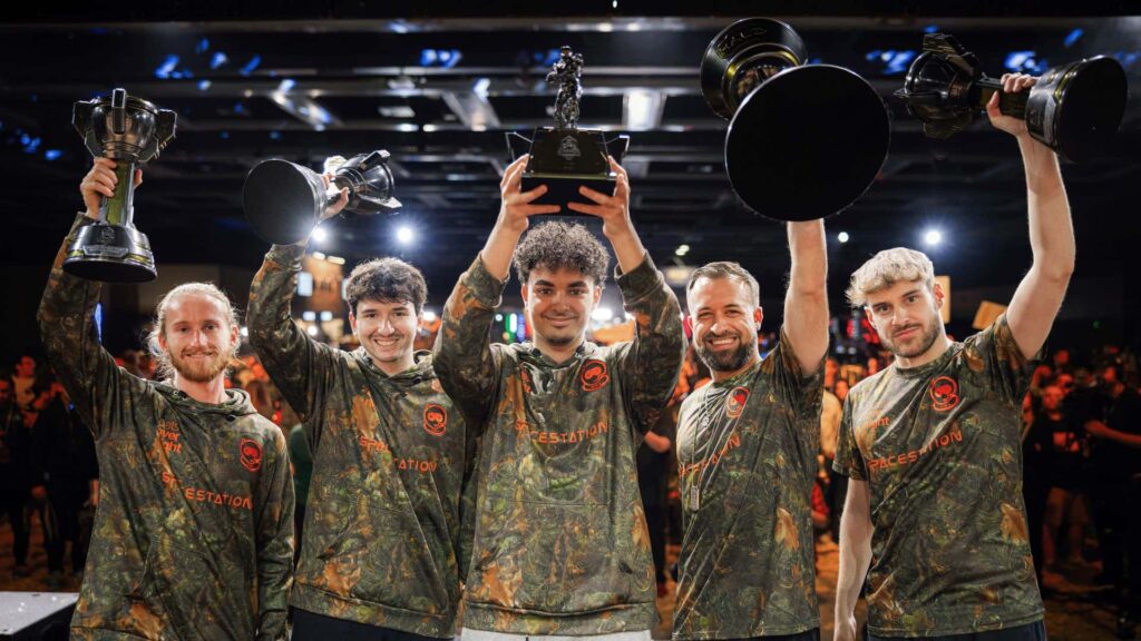 Cinco pessoas vestindo camisas camufladas comemoraram com troféus erguidos.