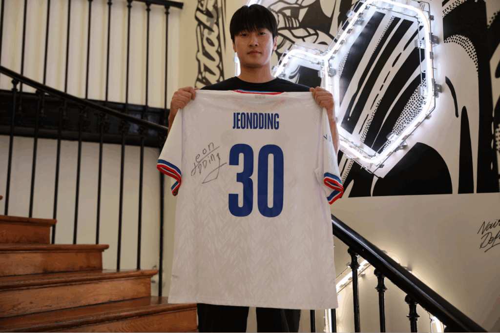 Jeondding holding a signed jersey photo