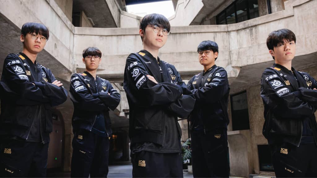 T1 Leeague of Legends Worlds team posing with arms folded while wearing black and gold teamwear