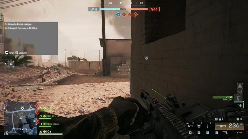 Captura de pantalla de un juego de campo de batalla con un jugador sosteniendo un arma en un área urbana desértica