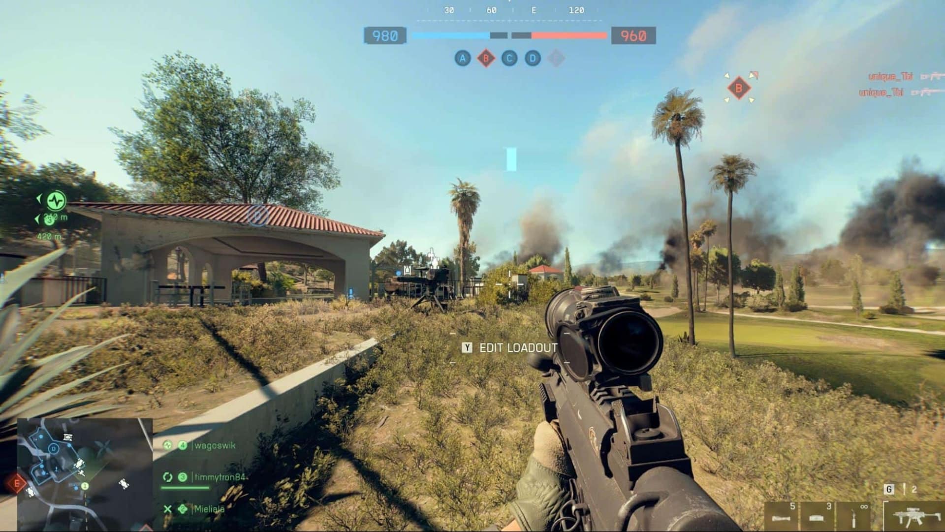 El juego Battlefield 6 presenta un rifle apuntando a una mansión con humo al fondo, palmeras y un cielo soleado.