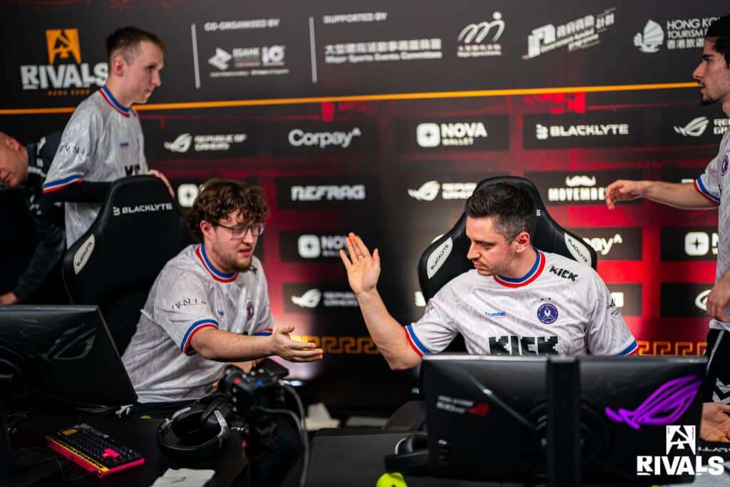Image of Team Vitality Counter-Strike players performing a high five while sat at gaming setup