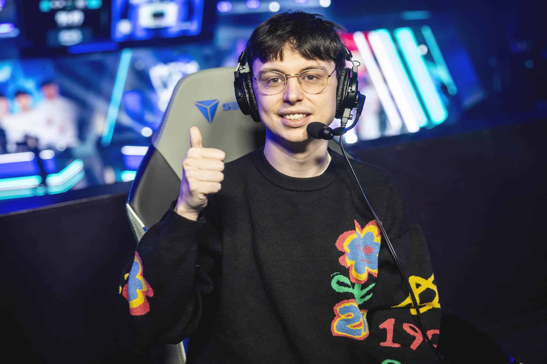 Image of Caedrel smiling with a thumbs up. An esports stage is in the background