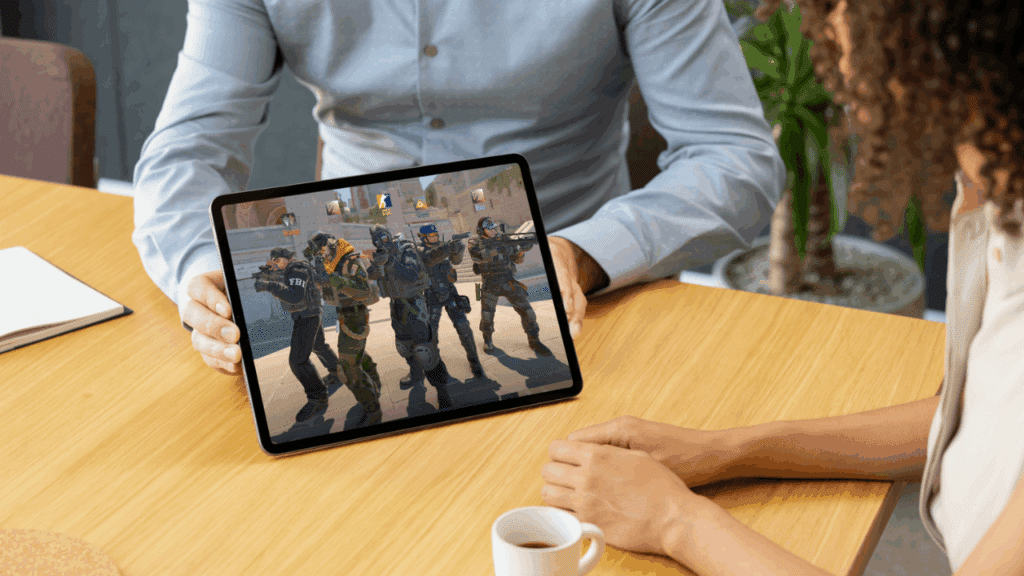 Two people staring at a tablet featuring Counter-Strike 2 in-game characters