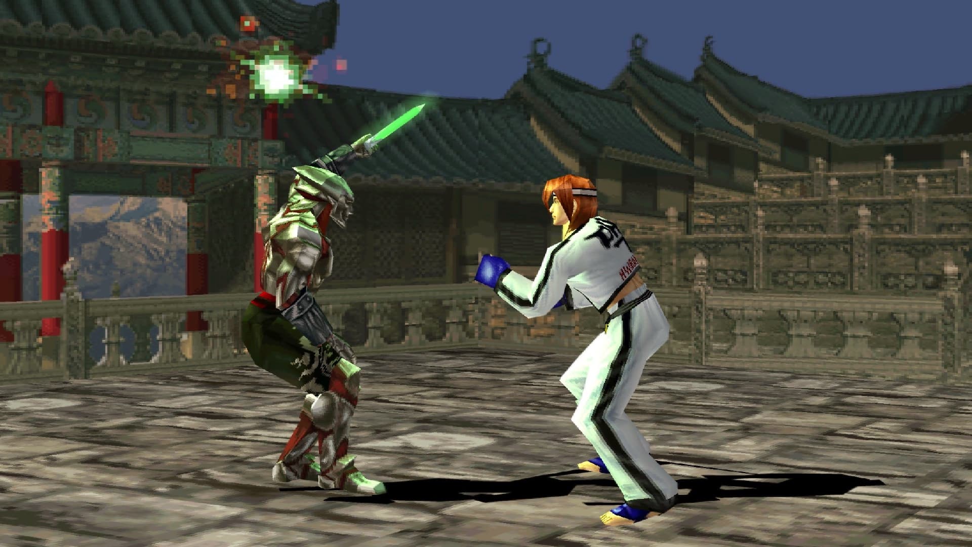 Lo screenshot mostra un combattimento tra i personaggi Yoshimitsu (a sinistra, in armatura e spada verde) e Hwarang (a destra, in abito bianco da taekwondo) del gioco Tekken 3.