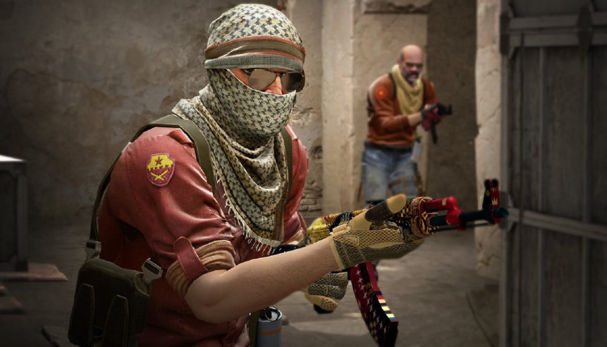 The image shows characters from Counter-Strike 2 (CS2), and the character in the foreground is holding a Kalashnikov assault rifle (AK-47) with a recognizable skin