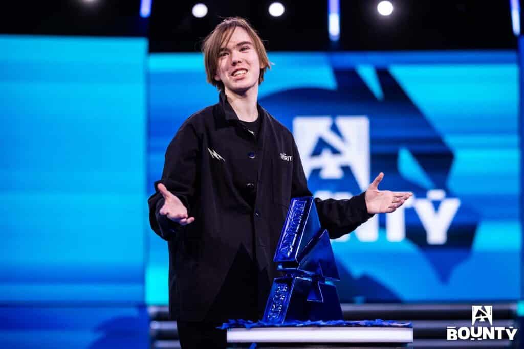 Image of Team Spirit Counter-Strike player donk raising hands near BLAST Bounty Season 1 trophy